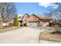 Charming brick home boasts a three-car garage and well-maintained landscaping at 2487 Wayward Wind Dr, Indianapolis, IN 46239