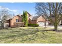 Beautiful brick home with a large front lawn and mature trees shading the property at 2487 Wayward Wind Dr, Indianapolis, IN 46239