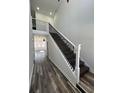Modern staircase with dark wood steps, white risers, and elegant wrought iron railings at 2819 Walker Ave, Indianapolis, IN 46203
