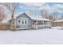 Cozy one-story house with a covered front porch and snow covered yard at 4080 N State Road 267, Brownsburg, IN 46112