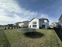 Spacious backyard with trampoline and black iron fence, perfect for outdoor entertaining and recreation at 4187 Risen Star Way, Bargersville, IN 46106