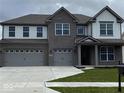 Elegant two-story home featuring a three-car garage, brick facade, and well-maintained front yard at 4187 Risen Star Way, Bargersville, IN 46106