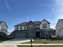 A beautiful two-story home boasts a two-car garage and inviting curb appeal with manicured lawn at 4187 Risen Star Way, Bargersville, IN 46106