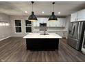 Modern kitchen with stainless steel appliances, center island, and sleek black pendant lighting at 4187 Risen Star Way, Bargersville, IN 46106