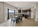 Eat-in kitchen with stainless steel appliances, dark cabinets, a kitchen island, and a view to the backyard at 4345 Indigo Walk Ln, Indianapolis, IN 46239