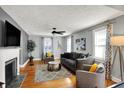Inviting living room featuring hardwood floors, a fireplace, neutral decor, and plenty of natural light from the windows at 5860 Indianola Ave, Indianapolis, IN 46220