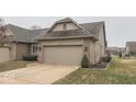 View of a cozy single-Gathering home with a two-car garage and well-manicured lawn at 613 Brook Dr, Greenwood, IN 46143
