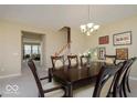 Inviting dining room with a dark wood table set for six, complemented by stylish decor at 9506 Oakley Dr, Indianapolis, IN 46260