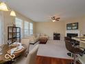 Open-concept living room featuring a fireplace, plush seating, and a view of the dining area at 9506 Oakley Dr, Indianapolis, IN 46260