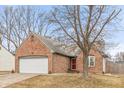 Charming brick home with a two-car garage and a well-manicured front lawn at 10156 Park Royale Dr, Indianapolis, IN 46229
