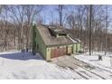 Two-story home featuring an attached garage and a quaint wooded lot covered in snow at 1032 E Woodall Ct, Martinsville, IN 46151