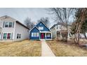 Inviting two-story home with a vibrant blue exterior, a welcoming red door and quaint front porch at 1038 W 33Rd St, Indianapolis, IN 46208