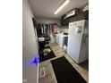 Laundry room including washer, dryer, refrigerator, hanging clothes, and a gray rug at 1130 W State Road 42, Mooresville, IN 46158