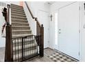 Inviting foyer showcasing staircase with a stair gate, complemented by modern flooring and a white front door at 1456 Bigleaf Dr, Sheridan, IN 46069