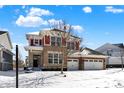 Charming two-story home featuring a brick facade, stone accents and covered front porch at 14905 W Blackwolf Run Dr, Carmel, IN 46033