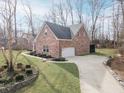 Side view of a beautiful brick home with an attached garage and pristine landscaping at 15921 Herriman Blvd, Noblesville, IN 46060