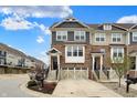 The townhome has brick and siding exterior with a two-car garage, front landscaping, and blue sky at 16057 Coleman Dr, Westfield, IN 46074