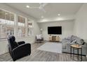Bright living room with large windows, gray flooring, and comfortable seating arrangement and ceiling fan at 16057 Coleman Dr, Westfield, IN 46074