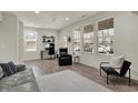 Bright living room featuring gray flooring, large windows, seating, work space and a ceiling fan at 16057 Coleman Dr, Westfield, IN 46074