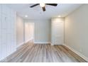 Bright living room featuring stylish gray wood floors, modern ceiling fan, and updated white wall at 3419 Carrollton Ave, Indianapolis, IN 46205