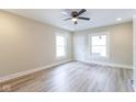 Bright living room featuring stylish gray wood floors, large windows, and updated white wall at 3419 Carrollton Ave, Indianapolis, IN 46205