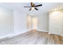 Bright living room featuring stylish gray wood floors, modern ceiling fan, and updated white wall at 3419 Carrollton Ave, Indianapolis, IN 46205
