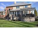 Beautiful backyard featuring a stone patio with pergola, overlooking lush lawn and architectural brick details at 3841 Falls Cir, Carmel, IN 46033