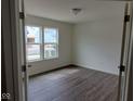 Bright bedroom featuring pristine white walls, wood-look flooring, and double windows at 4067 Denali Dr, Indianapolis, IN 46235