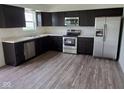 Modern kitchen with stainless steel appliances, dark cabinetry, and hardwood floors at 4067 Denali Dr, Indianapolis, IN 46235