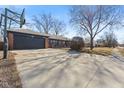 View of the house featuring a basketball hoop, long driveway, gray garage door and the home's address on the front at 429 Southmore St, Plainfield, IN 46168