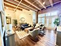Open-concept living area with exposed wood beams and brick accent wall at 430 N Park Ave # 302, Indianapolis, IN 46202