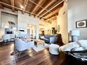 Open-concept living area with exposed wood beams and modern furnishings at 430 N Park Ave # 302, Indianapolis, IN 46202
