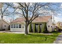 A cozy home with an inviting facade, complemented by a healthy lawn and mature tree at 506 Carol Dr, Greenwood, IN 46143