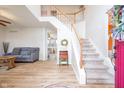 Bright foyer featuring hardwood floors, a staircase with white railings, and views into the living spaces at 538 Cyclamen Chase, Westfield, IN 46074