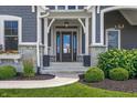 Inviting front entry featuring a stylish front door, stone accents, and manicured landscaping at 565 Old Ashbury Rd, Westfield, IN 46074