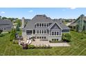 Stunning rear exterior with a spacious patio, outdoor kitchen, hot tub, and bocce ball court at 565 Old Ashbury Rd, Westfield, IN 46074
