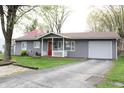 Gray single-story house with a garage, red front door and well-manicured lawn at 724 Center St, Franklin, IN 46131