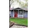 Close-up of the home's entry, featuring a red door with an oval window and small white porch at 724 Center St, Franklin, IN 46131