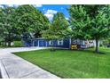 Charming navy blue home with manicured lawn, mature shade trees, and a detached garage with ample parking at 790 N 14Th St, Noblesville, IN 46060