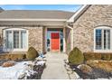 Inviting front entrance featuring a bright red door, brick facade, and manicured landscaping at 8717 Vintner Ct, Indianapolis, IN 46256