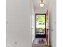Inviting entryway with neutral walls and a decorative rug by the red front door at 9788 Pine Ridge North Dr, Fishers, IN 46038