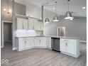 An open concept kitchen offers gray walls, white cabinets, and stainless appliances at 103 N Brenrich Rd, Pendleton, IN 46064