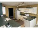 Well-lit kitchen features white cabinets, essential appliances, and generous countertop space, perfect for cooking at 1148 Nanwich Ct, Indianapolis, IN 46217