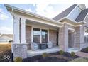 Inviting covered front porch with seating, featuring stylish brickwork and manicured landscaping, creating a welcoming entrance at 1225 Stonehaven Dr, Westfield, IN 46074