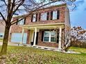 Charming brick home showcasing a welcoming porch and landscaped front yard at 1427 Broyles Ln, Indianapolis, IN 46231