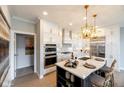 Modern kitchen boasts white cabinetry, stainless steel appliances, an island with bar seating and stylish pendant lighting at 16822 Imperial Ct, Fishers, IN 46040