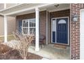 Inviting covered front porch with brick accents, a cozy seating area, and a stylish blue front door at 1763 Wedgewood Pl, Avon, IN 46123