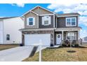 Charming two-story home with a stone-accented facade, two-car garage, and well-manicured landscaping at 1835 Fairmount Dr, Greenfield, IN 46140