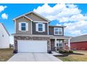 Charming two-story home with a stone-accented facade, two-car garage, and well-manicured landscaping at 1835 Fairmount Dr, Greenfield, IN 46140
