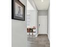 Welcoming hallway with light gray walls, wood-look floors, and decorative shelf with white bins for storage at 1835 Fairmount Dr, Greenfield, IN 46140